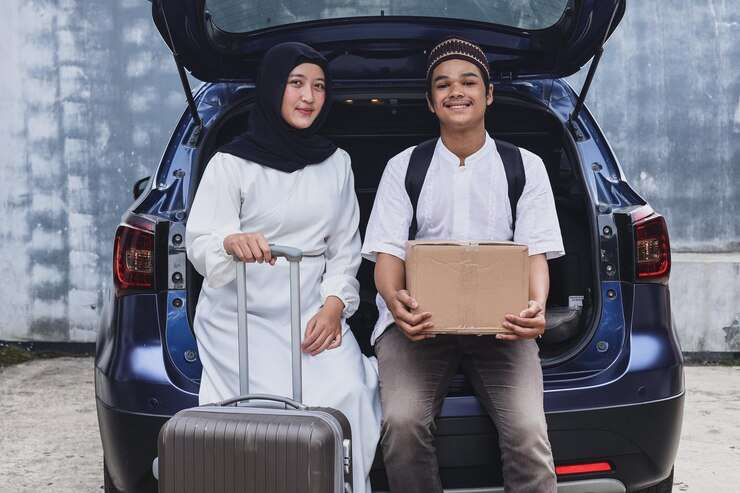 muslim couple are smiling sitting car trunk mudik lebaran eid moment